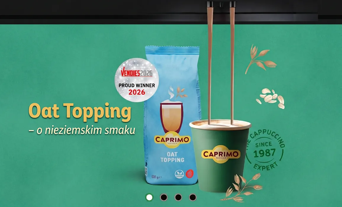 Opakowanie wegańskiego dodatku owsianego Caprimo Oat Topping i zielony kubek napełniany kawą z automatu z odznaką zwycięzcy Vendies 2026.